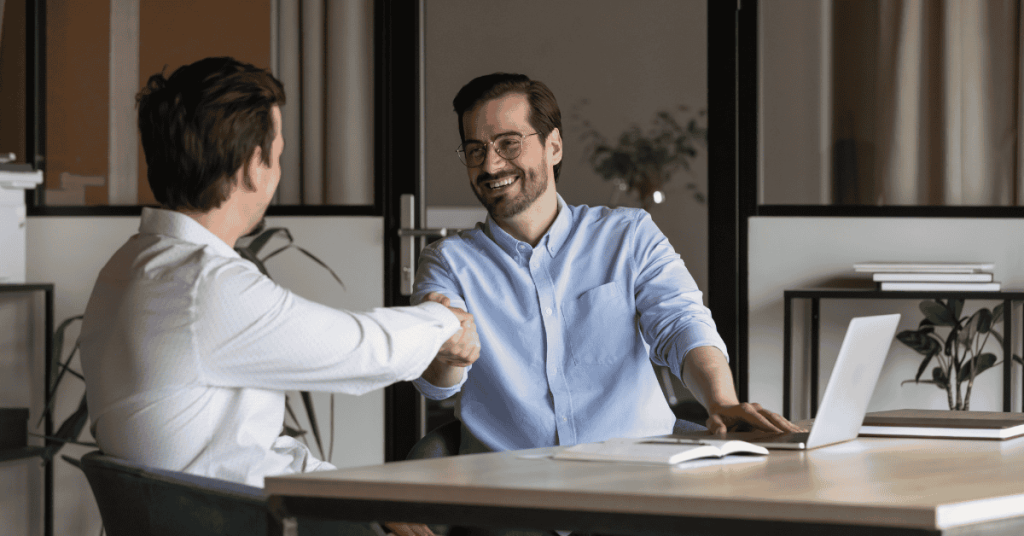 Dos colegas sellando un acuerdo de investments durante una reunión de negocios en la oficina.