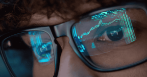 Persona observando gráficos de mercado en la pantalla, analizando datos bursátiles y tendencias de investments.