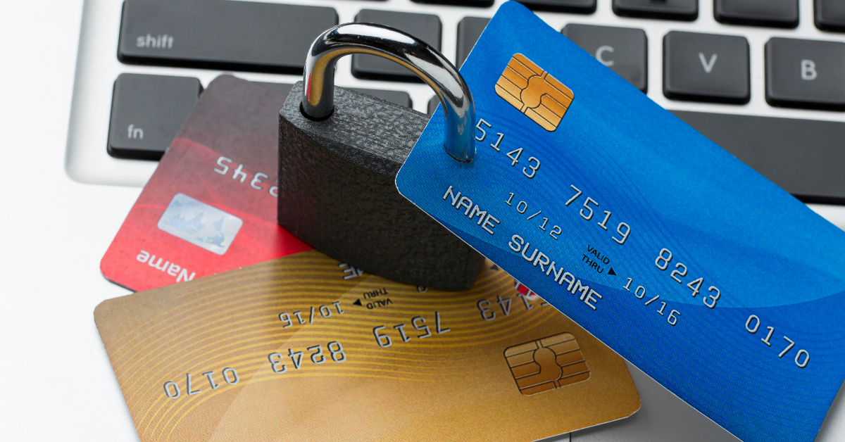 Tarjetas de crédito con un candado sobre un teclado de computadora, simbolizando seguridad y protección de datos financieros.