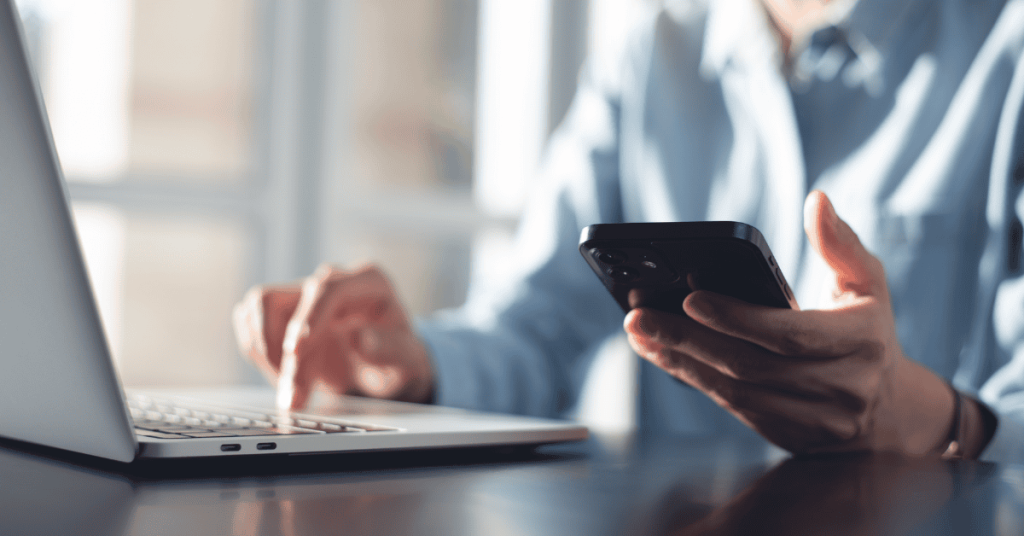 Persona gestionando sus finanzas personales online con su tarjeta de crédito desde la computadora y el celular.