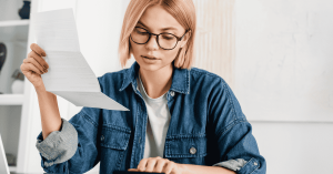 Mujer analizando sus finanzas personales y calculando sus investments en un entorno de trabajo en casa.
