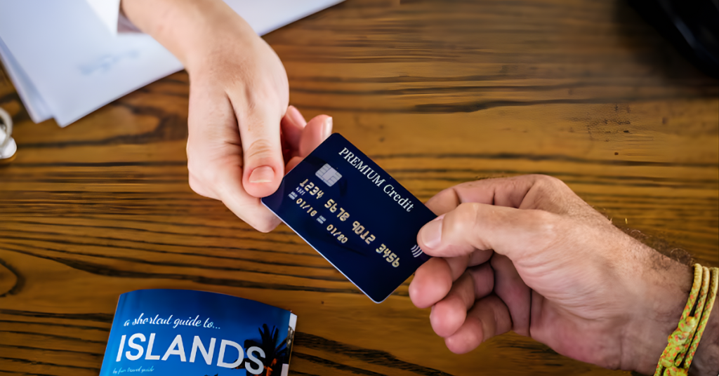 Persona entregando una tarjeta de crédito sobre una mesa, simbolizando pagos seguros y consumo responsable.