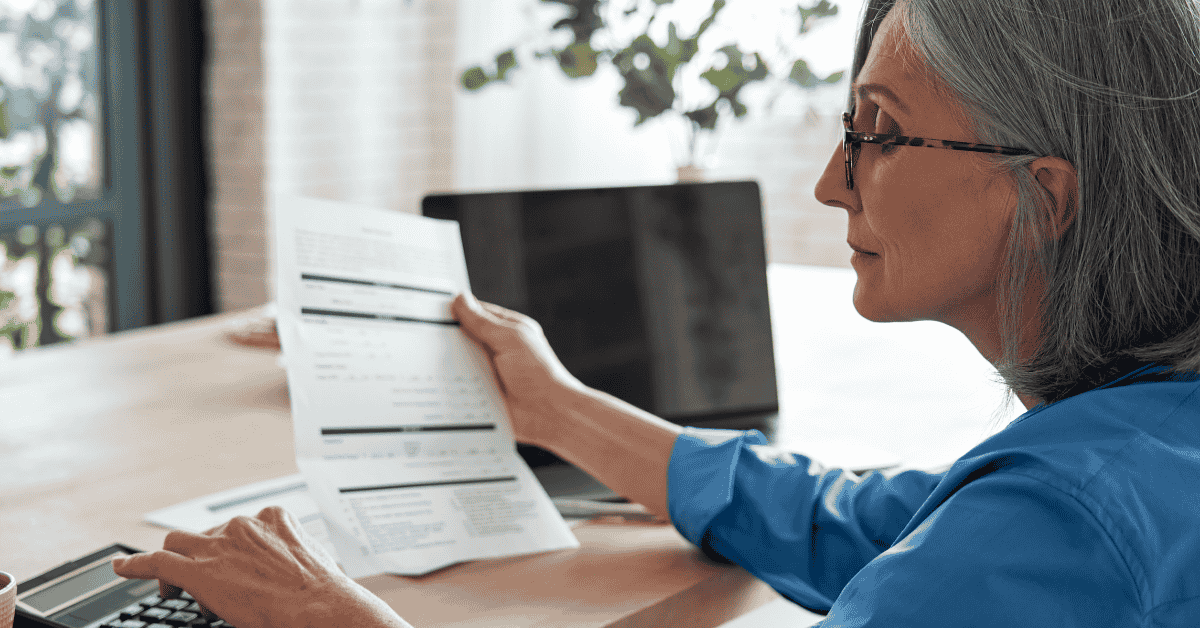Mujer revisando el resumen de su tarjeta de crédito y controlando gastos en línea desde su casa.